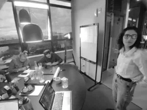 alt="Equipe da trasso interagindo com os clientes durante uma consultoria de branding dentro de um escritório"
